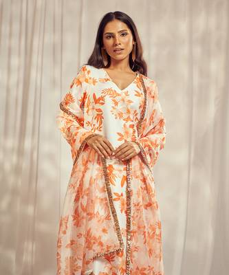 Burnt orange print kurti set paired with matching bottom and star organdie dupatta with gold trimming lace detailing. 3