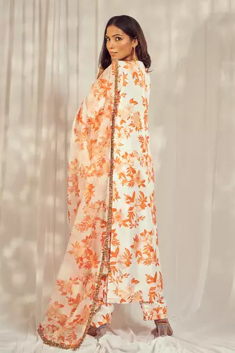 Burnt orange print kurti set paired with matching bottom and star organdie dupatta with gold trimming lace detailing.