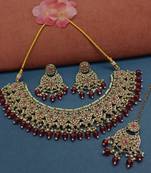 Elegant maroon and gold kundan choker necklace set with earrings and maang tikka