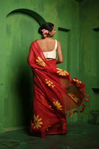 Huts and looms red handloom cotton saree, featuring exquisite hand-painted floral designs throughout the saree.