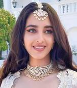 Elegant bridal jewelry set with pearl choker and ornate maang tikka