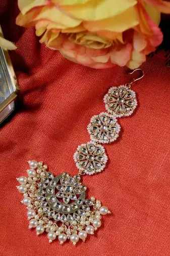 Elegant bridal jewelry set with pearl choker and ornate maang tikka