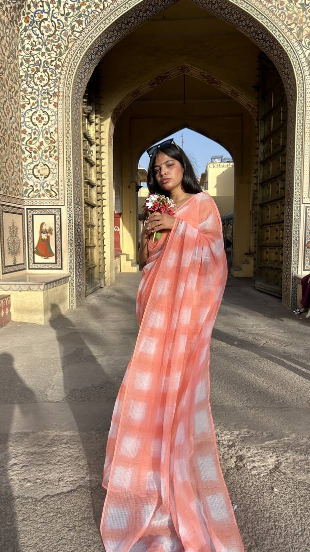 Grace and tradition meet in the exquisite Kota Doria Peach Saree.