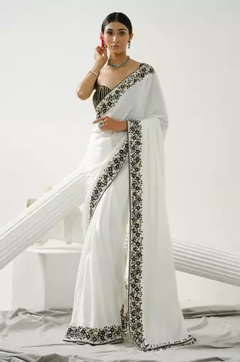White floral border saree paired with black geometric cutdana blouse