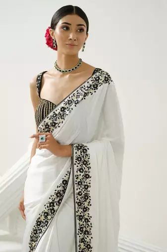 White floral border saree paired with black geometric cutdana blouse