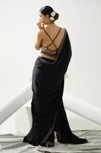 Black geometric satin silk saree paired with a sequin embellished  cross back strap blouse