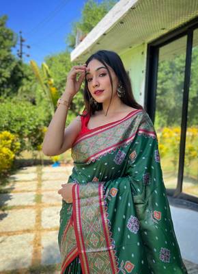 Green patola silk saree and has a  zari border blouse piece 2