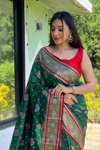 Green patola silk saree and has a  zari border blouse piece