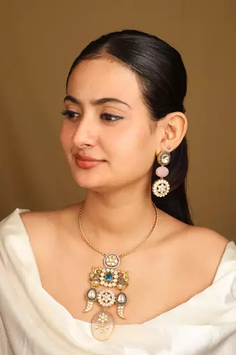 Gold necklace set with stone-studded pendant and matching earrings