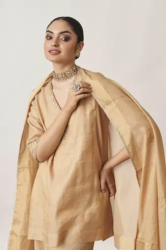 The gold silk tissue chanderi gharara set with pittha handwork