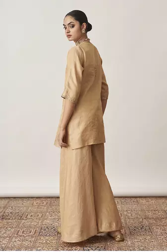The gold silk tissue chanderi gharara set with pittha handwork