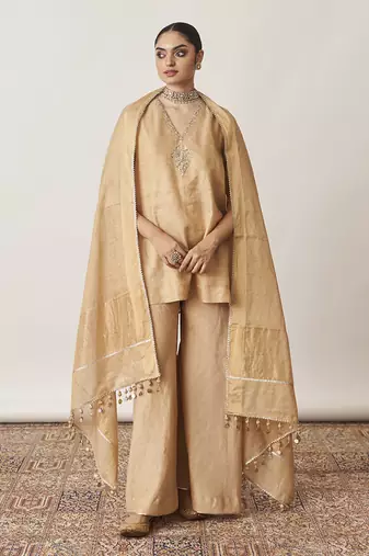 The gold silk tissue chanderi gharara set with pittha handwork