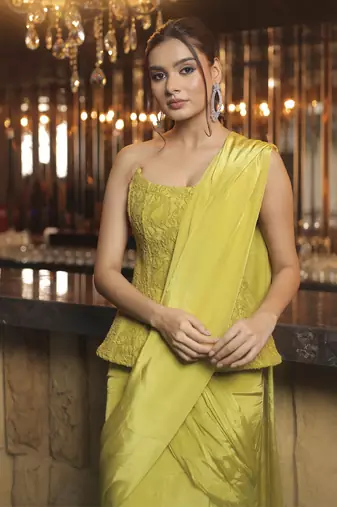Parrot green pre draped saree with corset blouse in chantley net.