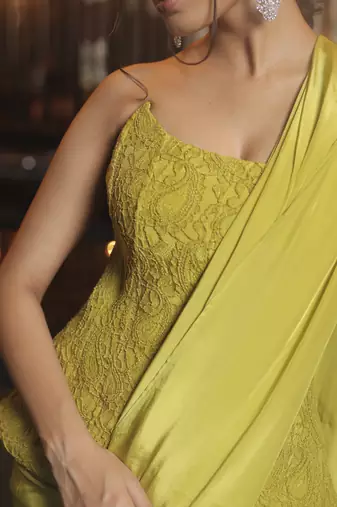 Parrot green pre draped saree with corset blouse in chantley net.