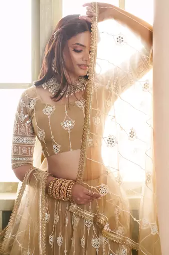 BEIGE NET FABRIC LAHENGA CHOLI WITH SEQUINS AND THREAD EMBROIDERY WORK