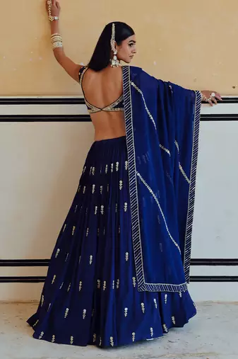 DEEP NECKLINE EMBROIDERED SLEEVELESS BLOUSE WITH FLORAL BUTTI EMBROIDERED LEHENGA AND DUPATTA