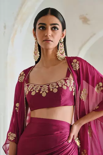Magenta floral embroidered neckline bralet with floral butti embroidered jacket and cowl skirt.