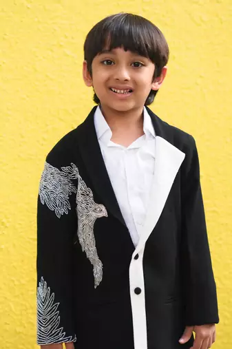 Stylish black blazer with silver embroidery and white lapel, paired with black trousers