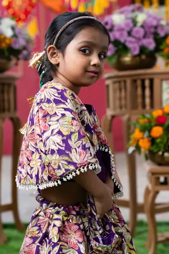 Elegant embroidered lehenga with attached floral cape and matching potli bag