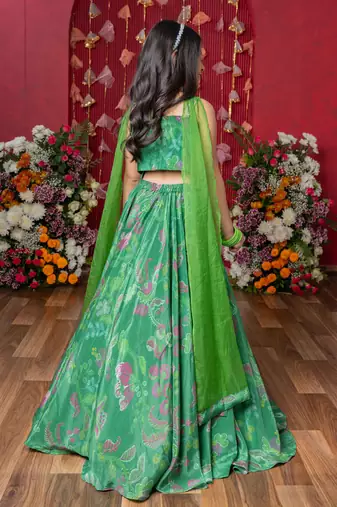 Grace your festivities with this vibrant green lehenga set, featuring floral embroidery and a flowy printed skirt