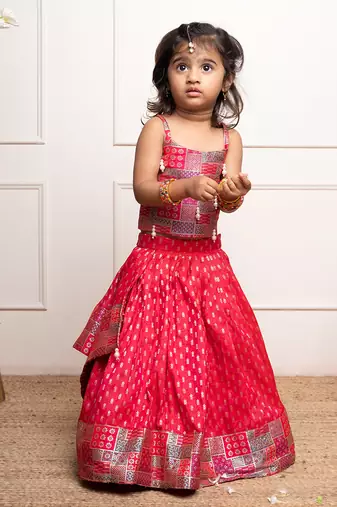 Vibrant red lehenga set with a multicolored patchwork blouse and golden motif print, perfect for festive occasions