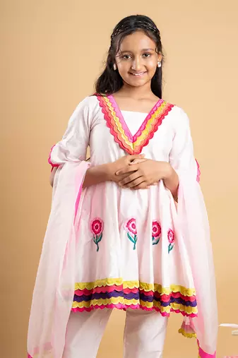 Charming white kurta set with colorful scalloped details and floral embroidery, perfect for festive occasions