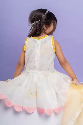 Charming white dhoti-style set with floral embroidery and playful yellow and pink accents, perfect for festive occasions