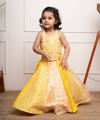 Vibrant yellow sleeveless dress with playful prints and tassel accents. 1