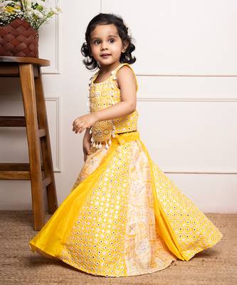 Vibrant yellow sleeveless dress with playful prints and tassel accents. 2