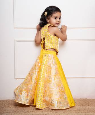 Vibrant yellow sleeveless dress with playful prints and tassel accents. 3