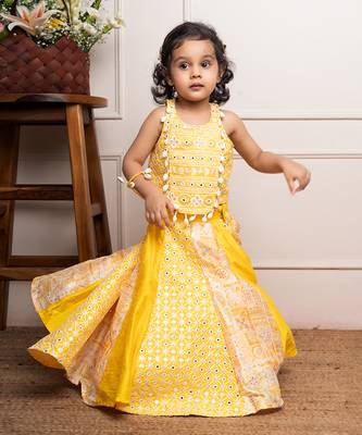 Vibrant yellow sleeveless dress with playful prints and tassel accents. 4