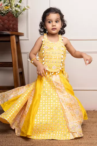 Vibrant yellow sleeveless dress with playful prints and tassel accents.