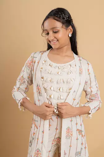 Vibrant ivory ensemble with colorful prints and tassel accents