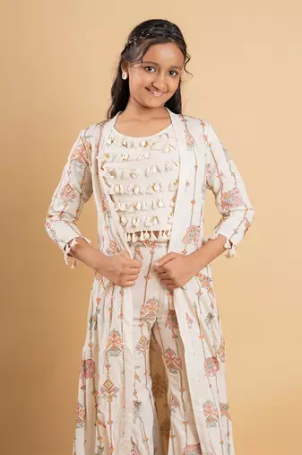 Vibrant ivory ensemble with colorful prints and tassel accents