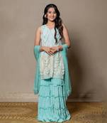 Elegant mint green ensemble with intricate beadwork and layered pants