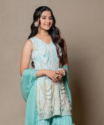Elegant mint green ensemble with intricate beadwork and layered pants 3
