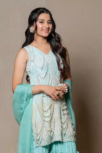 Elegant mint green ensemble with intricate beadwork and layered pants
