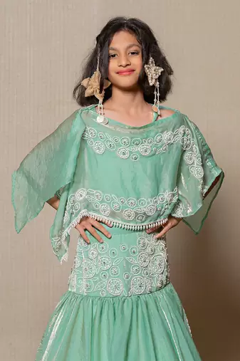 Elegant mint green top and lehenga with intricate white embroidery and a flowing silhouette