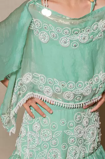 Elegant mint green top and lehenga with intricate white embroidery and a flowing silhouette