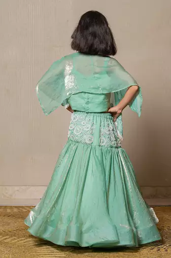 Elegant mint green top and lehenga with intricate white embroidery and a flowing silhouette
