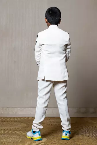 Modern off-white suit with blackaccents and stylish embroidered sleeve detail