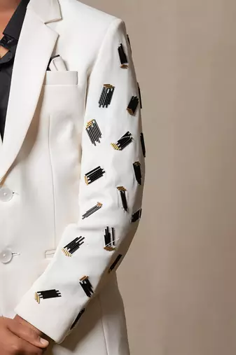 Modern off-white suit with blackaccents and stylish embroidered sleeve detail