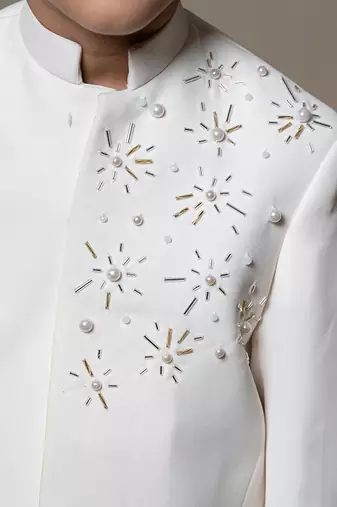 Ivory white bandhgala jacket with intricate pearl and sequin embellishments paired with matching straight-fit pants