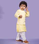 Elegant soft yellow kurta with intricate white embroidery, paired with classic white churidar pants