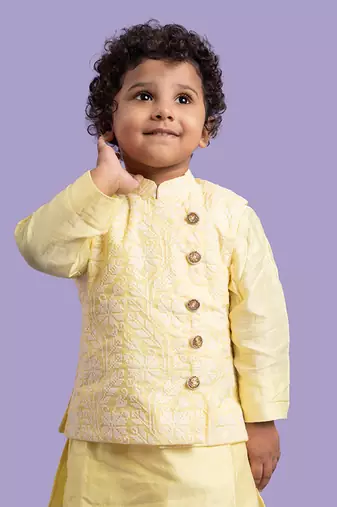 Elegant soft yellow kurta with intricate white embroidery, paired with classic white churidar pants