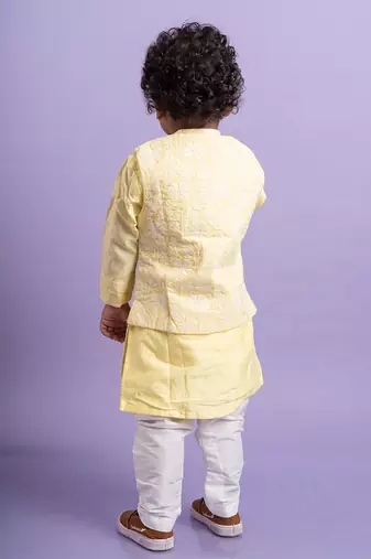 Elegant soft yellow kurta with intricate white embroidery, paired with classic white churidar pants