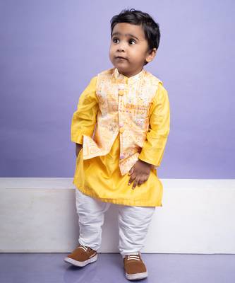 Vibrant yellow kurta set with an embroidered peach nehru jacket, paired with classic white churidar pants 1