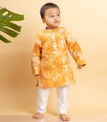 Bright orange tie-dye kurta with classic white pants
