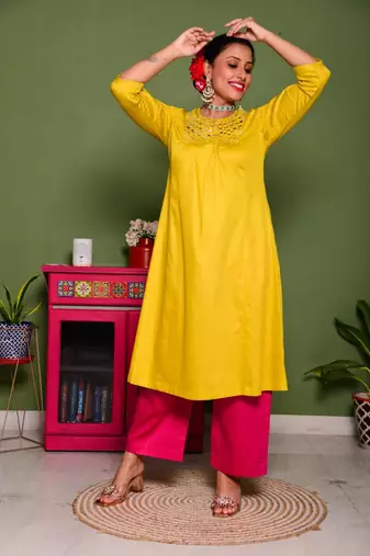 Two piece mustard colored suit with hand embroidered mirror work long kurti paired with contrast trouser