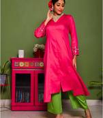 Two piece magenta colored suit with hand embroidered mirror work on sleeves paired with contrats trouser